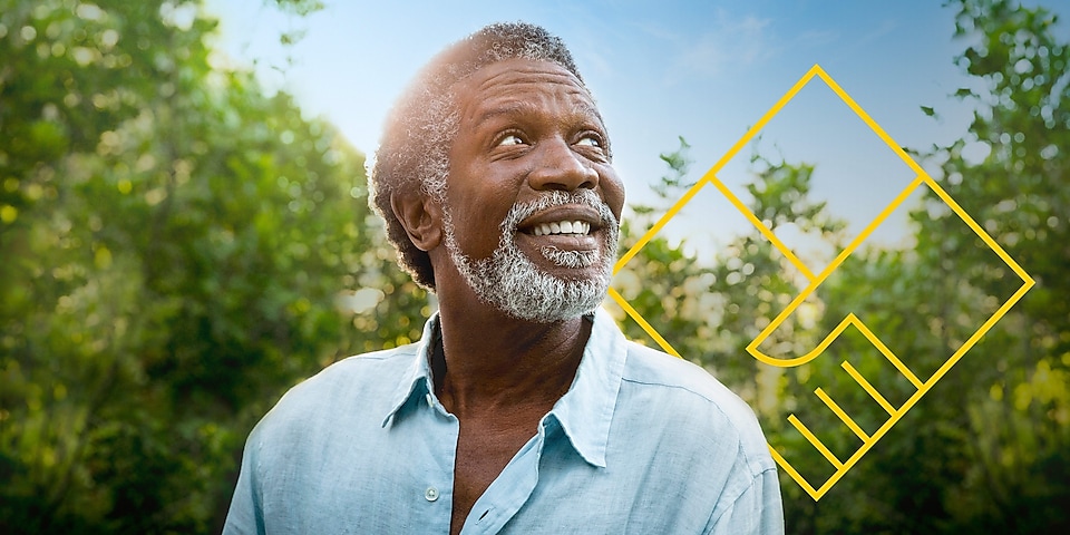 Hombre sonriente, con barba, entre árboles junto al contorno del símbolo correspondiente a «Generar valor para el accionista»