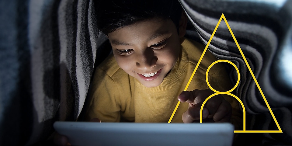 Foto de un niño mirando una tableta con el contorno del símbolo correspondiente a «Impulsar vidas»