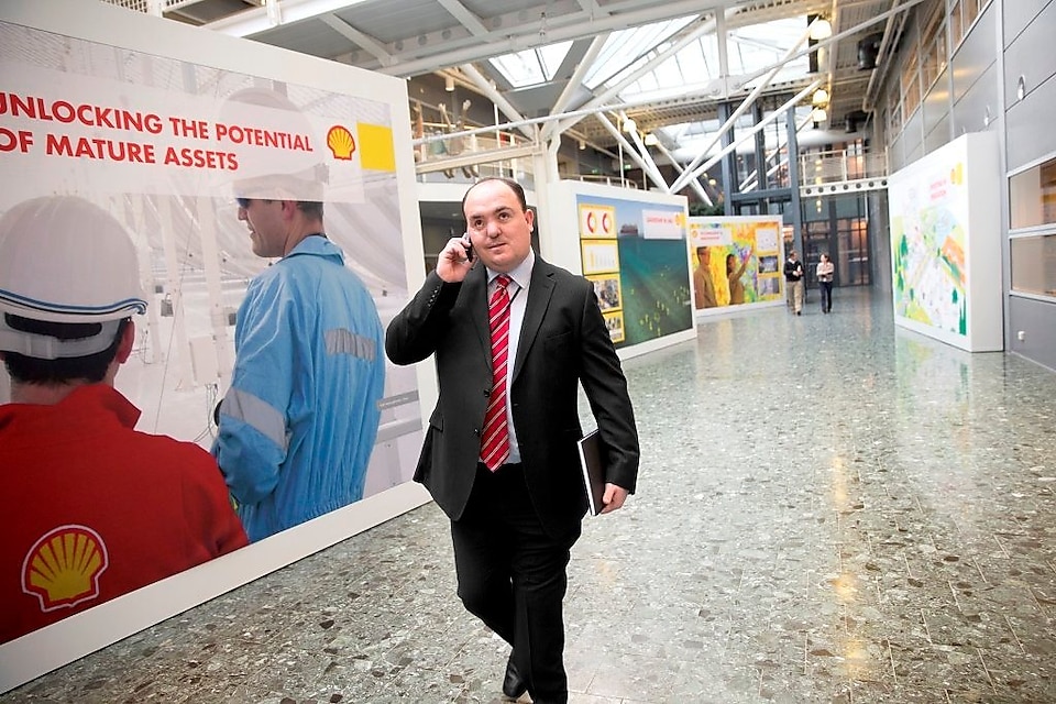 Andy Kneen, caminando y hablando por teléfono en la oficina de Shell