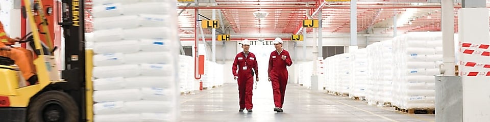 Dos empleados andando por una fábrica