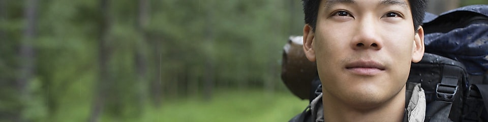 Retrato de un mochilero asiático en el bosque