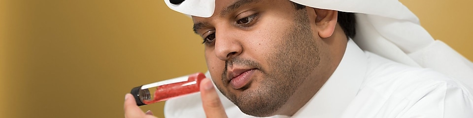 Mohammed Al Athba examina el contenido de un tubo de ensayos con tapa