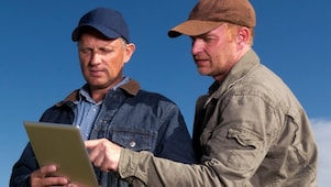 Dos personas en un entorno agrícola, ilustrando las soluciones de lubricación de Shell para el sector agrícola