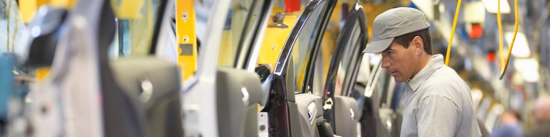 man holding wire looking at machine