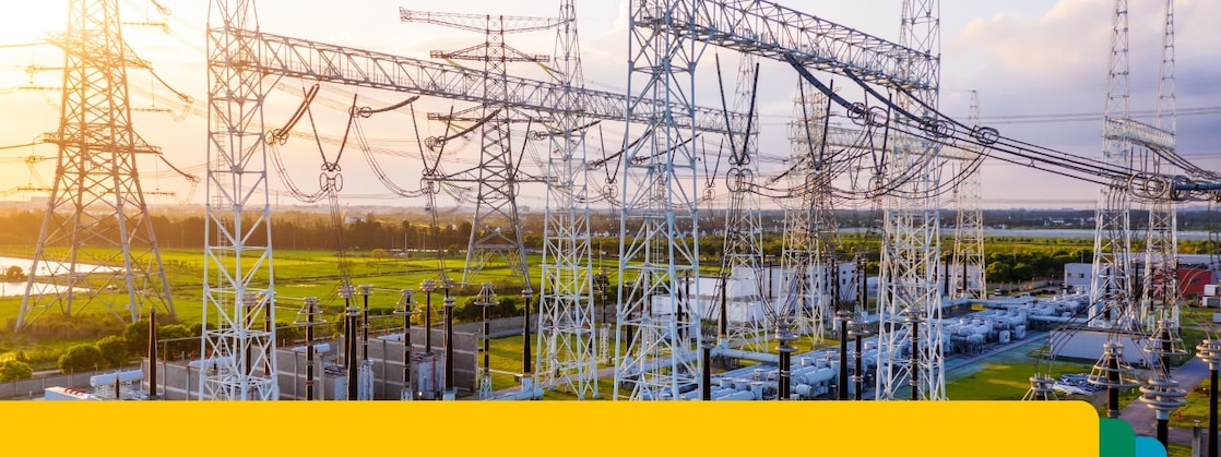 Transformatorstation met onderling verbonden hoogspanningsleidingen en apparatuur bij zonsondergang.