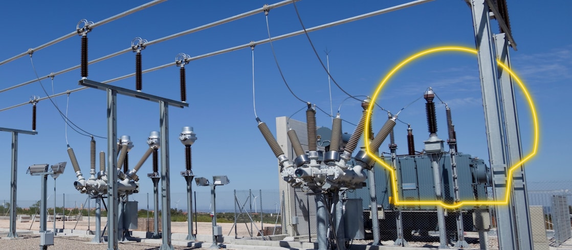 Una fotografía de un transformador con la salida del sol detrás 