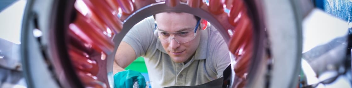 Hombre introduciendo gránulos de plástico en una máquina mezcladora