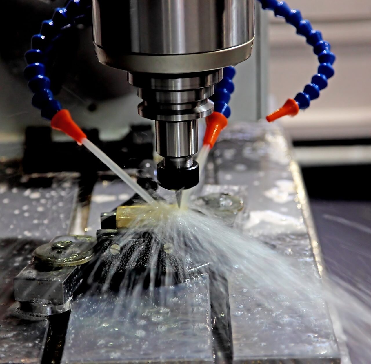 An oil drill being worked, and water being pumped onto it to help cool it down