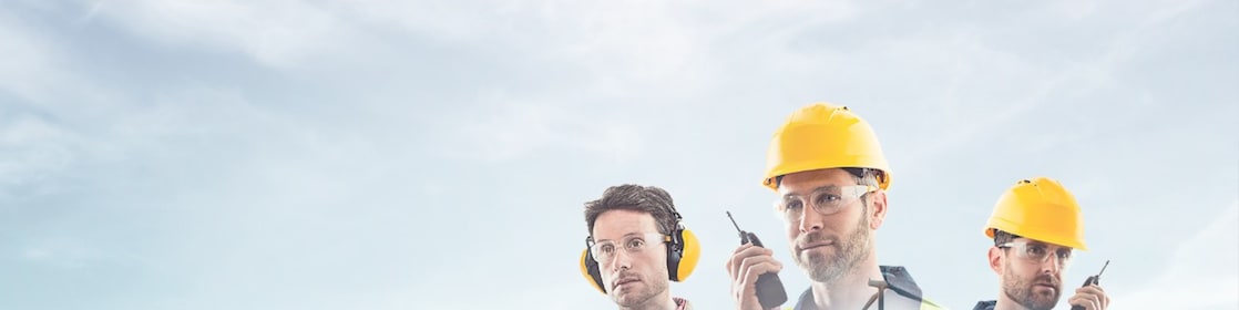  three workers on radios and reading documents, transposed over a background of blue sky with light clouds