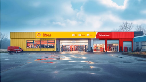 Vista de un taller de camiones de la marca Shell. El edificio tiene una fachada amarilla y roja con el logotipo de Shell y 'Shell Rimula' en un lugar destacado.