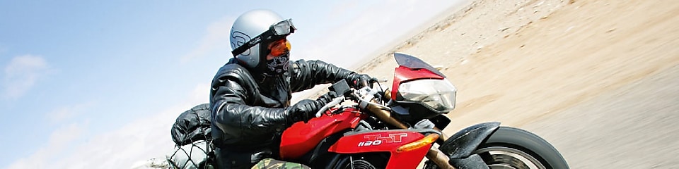 Gary Inman conduciendo una motocicleta por el desierto