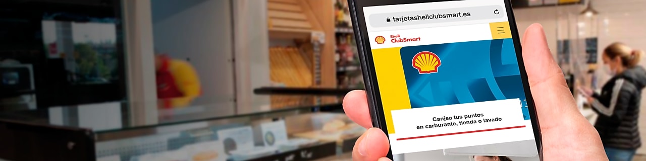 Mano con movil dentro de una tienda Shell