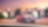 Coche rojo estacionado en el exterior de una casa con los faros encendidos al atardecer