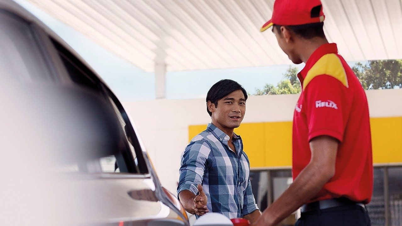 Personas repostando en una estación de servicio