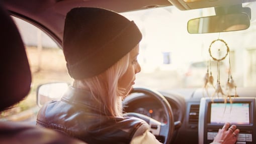Una joven consulta las instrucciones mostradas en la pantalla de navegación integrada en su coche