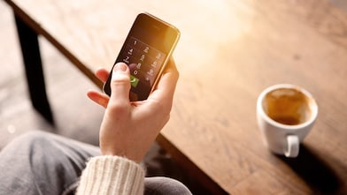 Imagen de teléfono móvil junto a taza de café