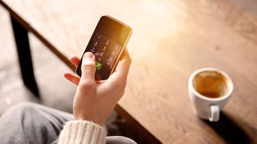 Imagen de teléfono móvil junto a taza de café