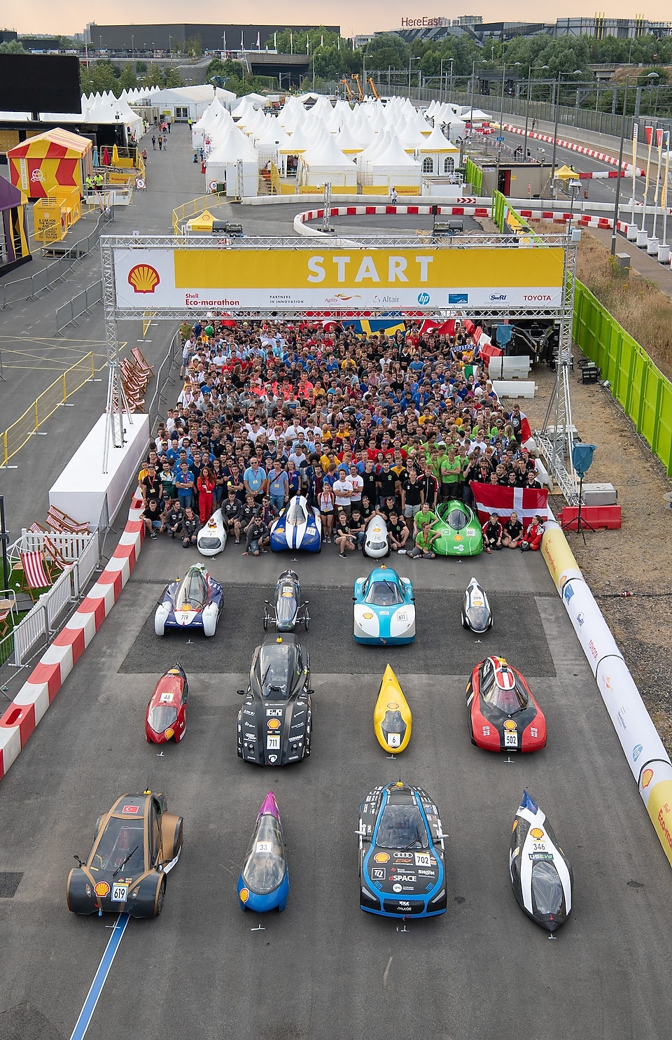 Team members and their cars are lined up on the grid for a group photograph on the eve of Make the Future Live 2018